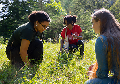 three students in the grass