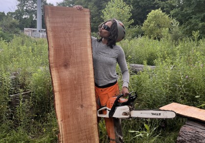 person with a chainsaw and a cut piece of wood