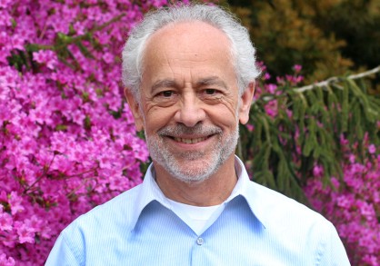 Christopher Dunn head shot in front of a pink flowering bush